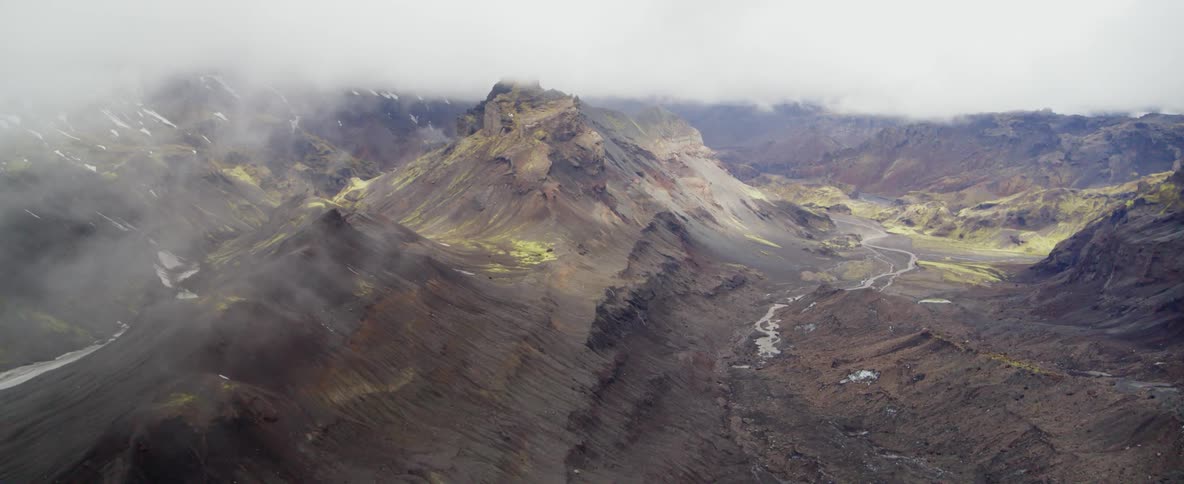 Mist rolls over jagged rocky hills
