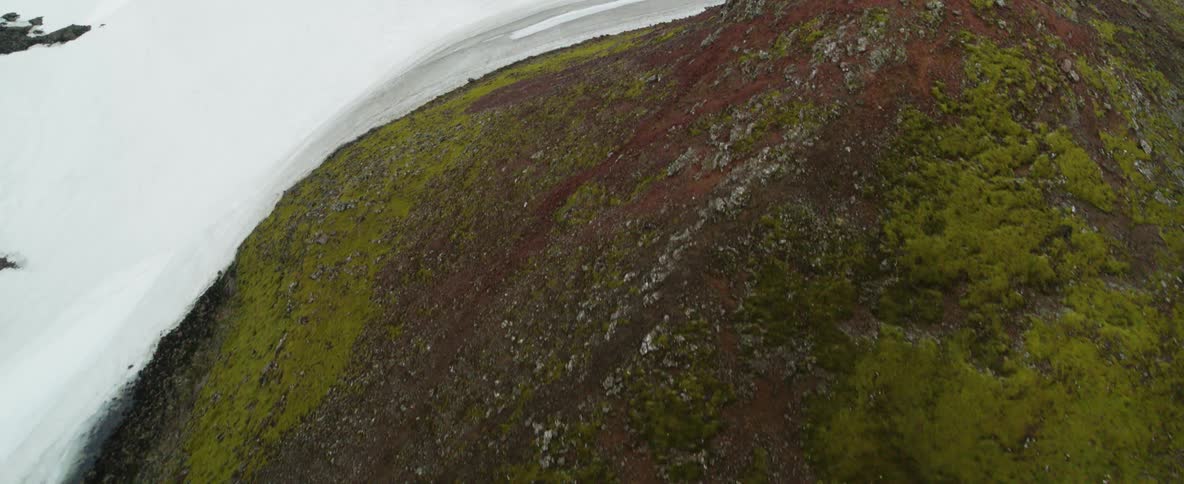 Snow packs the area between two mountains