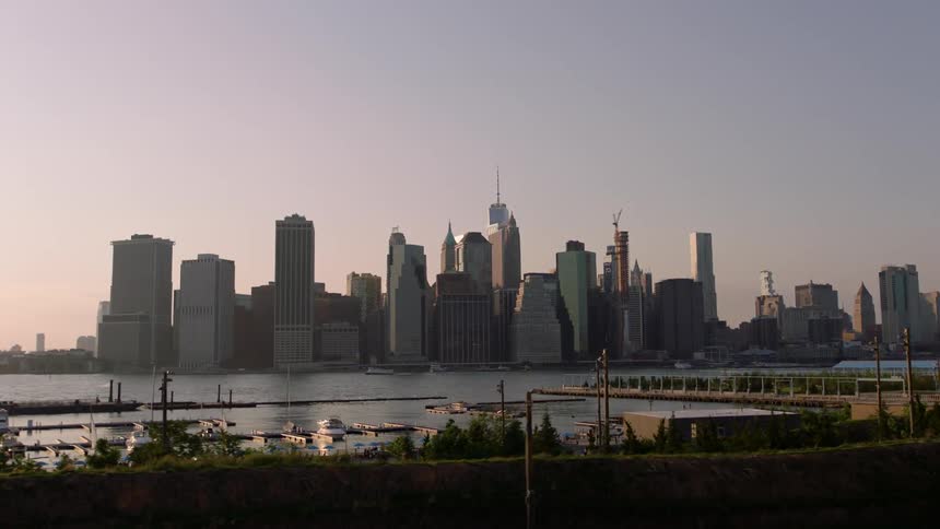 Skyscrapers stand next to a river at sunset