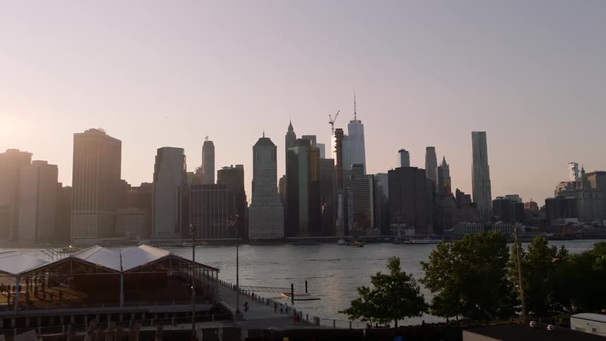 The sun is rising over a city with a harbor