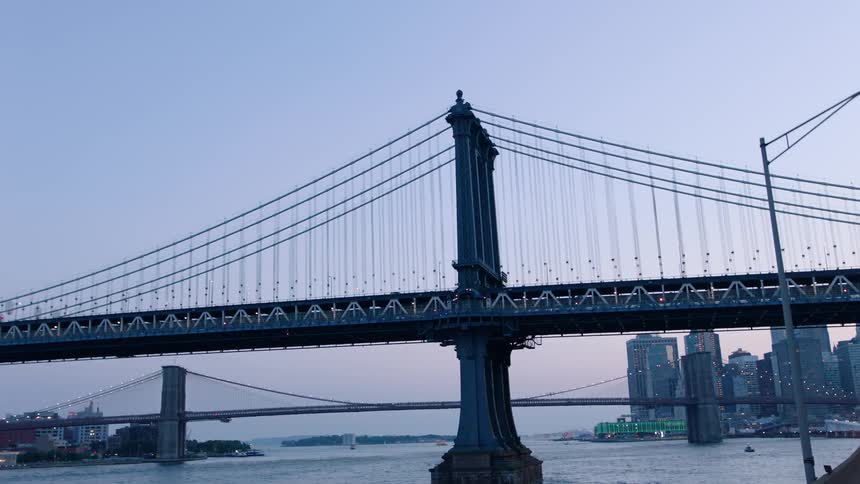 Cars drive on a city bridge at sunrise
