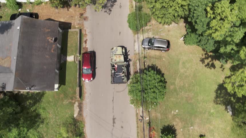 Humvee drives on a neighborhood road on a sunny day