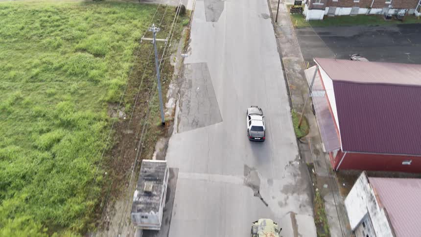 A police car escorts humvees down the road