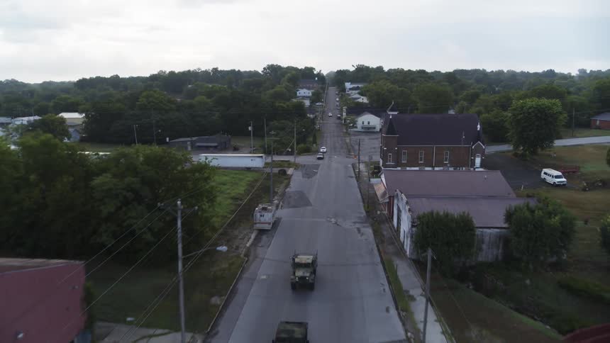 Cars drive on a town street