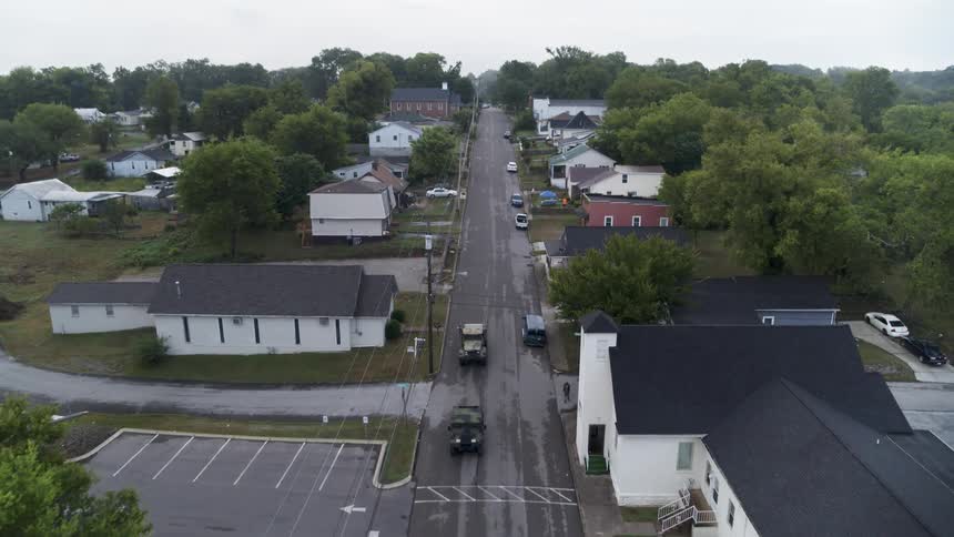 Cars drive down a town road