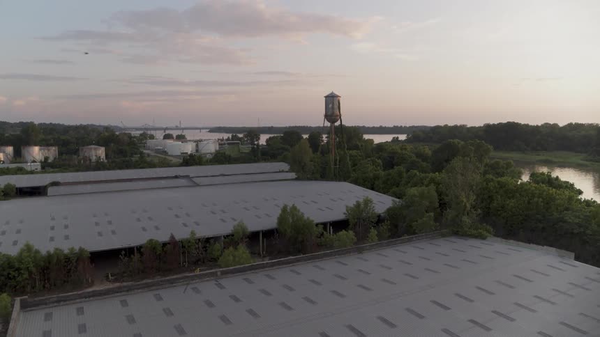 A water tower stands tall above industrial buildings