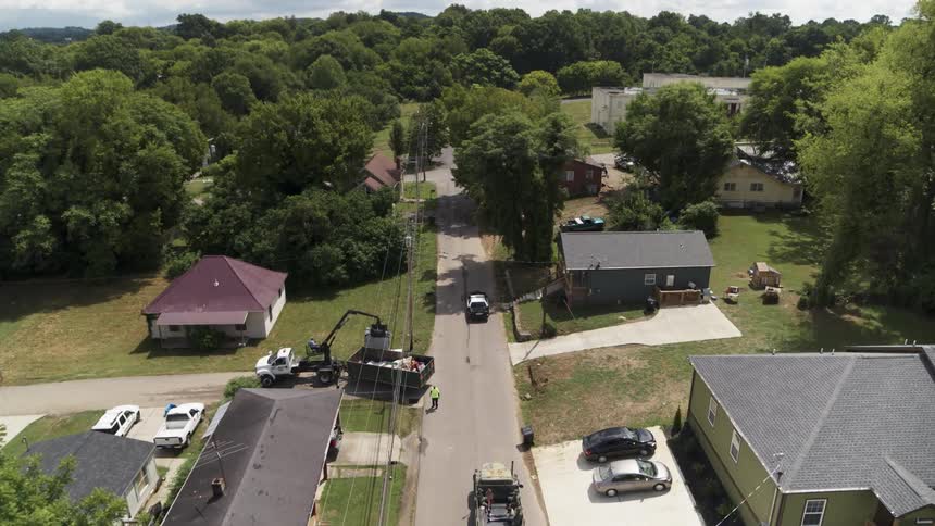 Cars drive on a neighborhood street