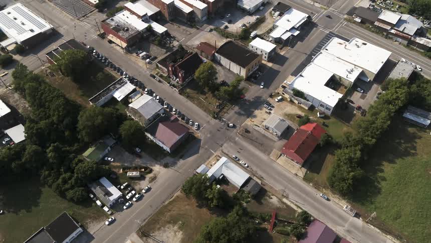 A car is following another car along a town's streets during the day