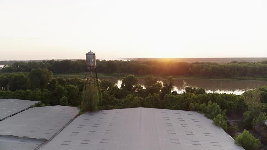 Sunlight is gleaming off wetlands near a farming community at dawn