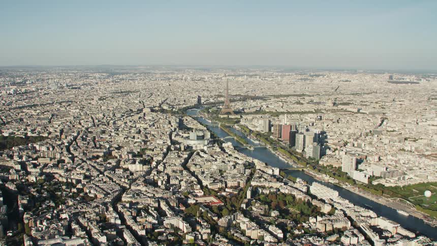 The eiffel tower stands tall above the other city buildings near the canal
