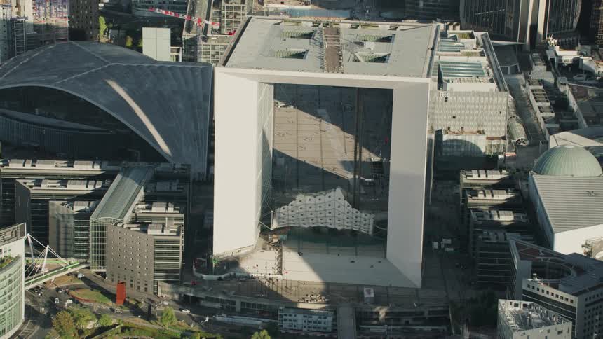 A square building in the middle of a large city