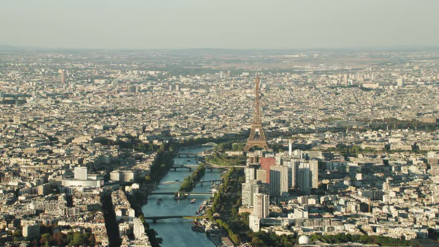 The eiffel tower stands tall above the other city buildings near the canal