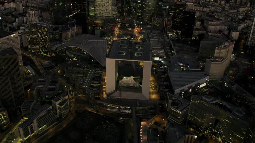 Lights illuminate the  architecture of buildings in a city at night