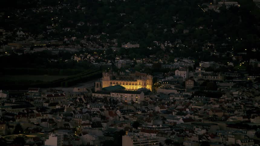 Lights illuminate an old building in a city at night