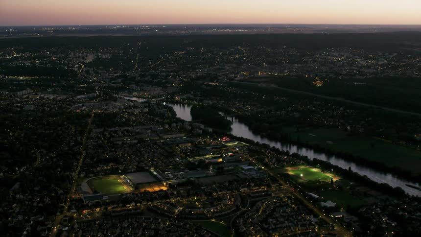 City lights glow as the sun sets on the horizon