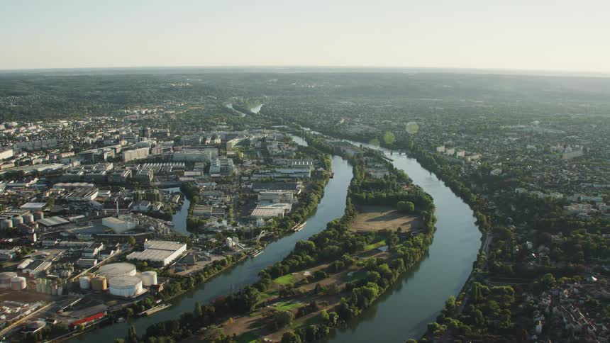 A river is flowing through an industrial area in a community during the day