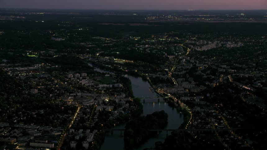 A large city with a river snaking through it at night