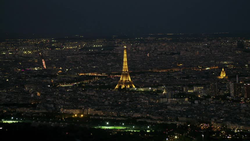 A beam of light emanates from the eiffel tower at night