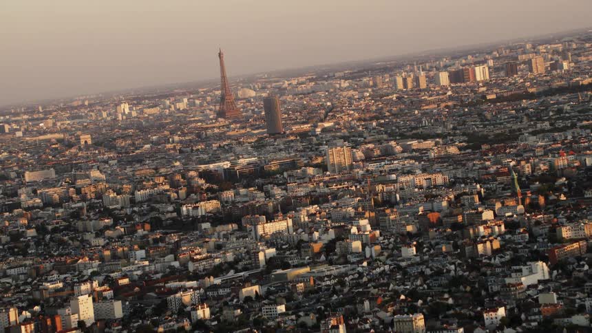 The eiffel tower stands in the distance at sunset