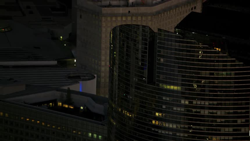 Tall city buildings illuminate the night sky