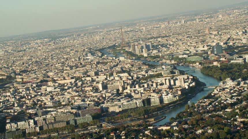 The seine river is flowing past the eiffel tower on a smoggy day