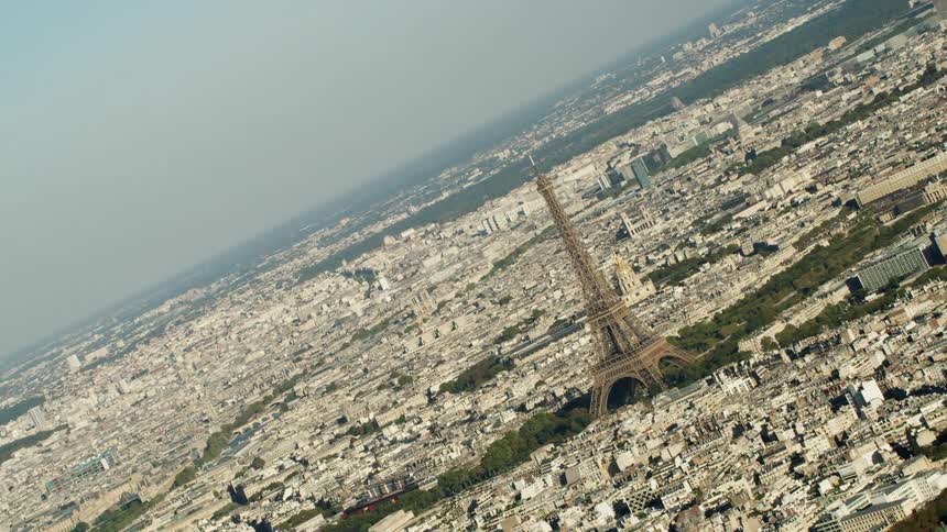 The eiffel tower stands tall above the other city buildings near the canal