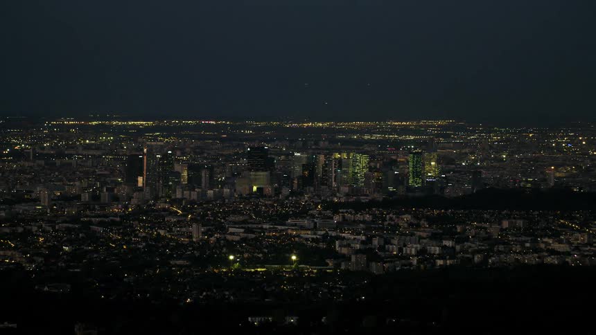 A large city skyline is viewed at night