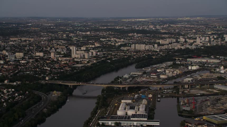 Vehicles travel over a bridge across a river in a city