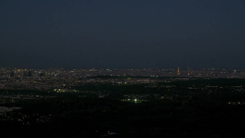 A large populated city is viewed from a flying drone at night