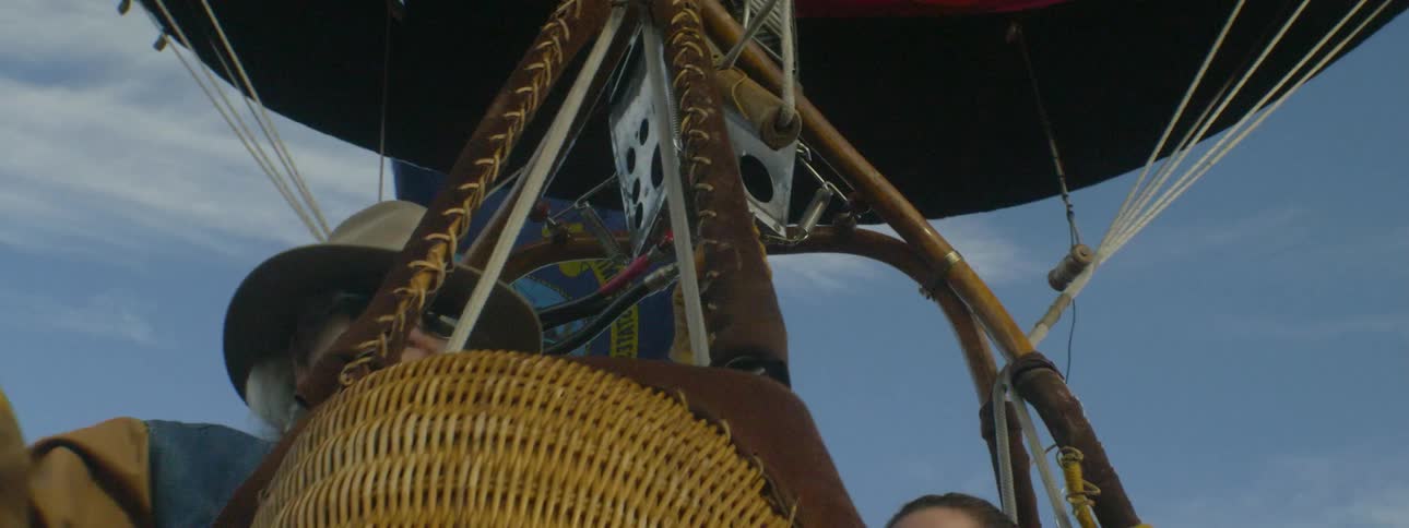 A woman is piloting a hot air balloon at dusk