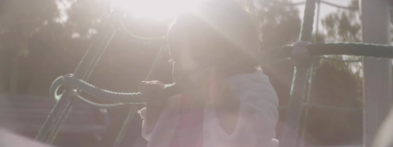 A young girl sits on a playground spin ride