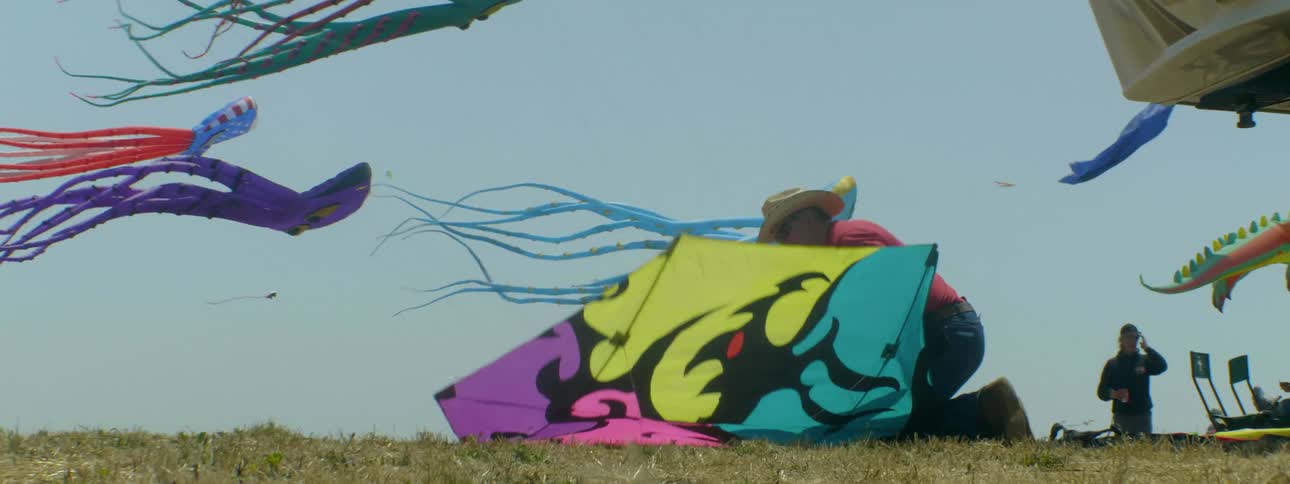 A man is preparing to fly a kite on a windy day