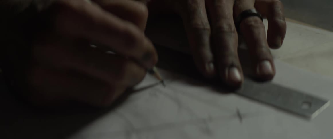 A man marks lines on blueprints