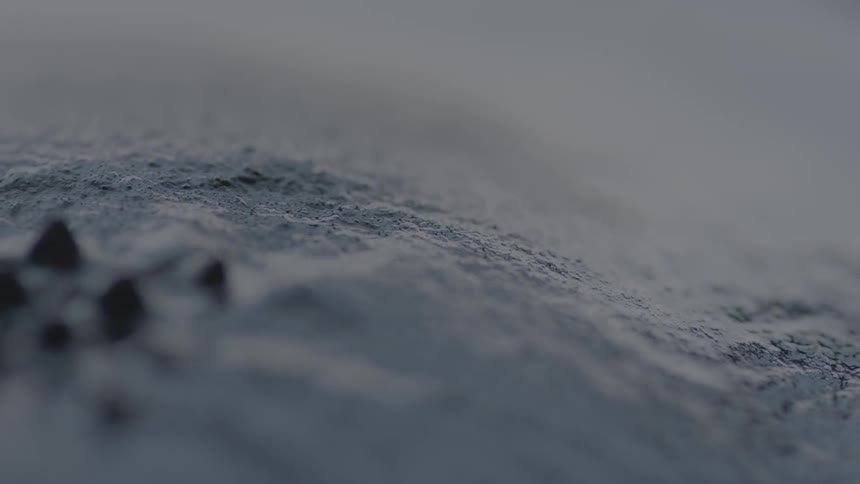 Black liquid ripples up into a spiked pattern