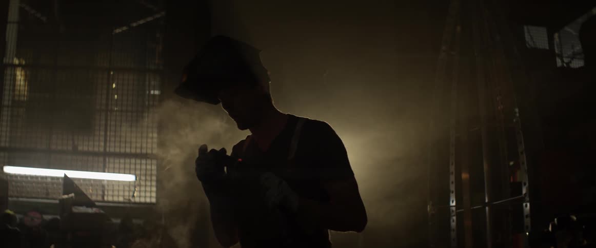 A man blows smoke off of a hot pipe