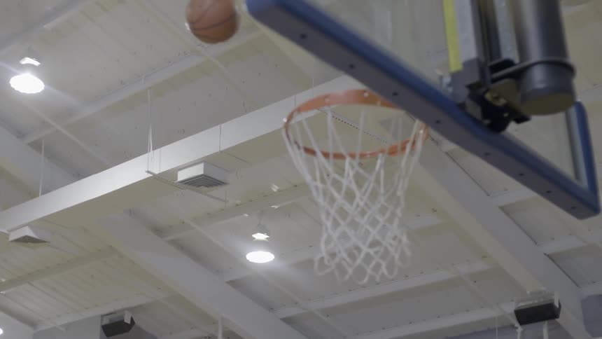 Two men on a basketball court; one shoots and misses