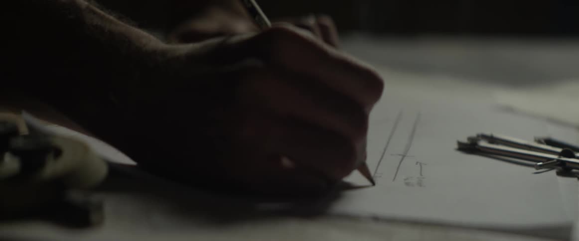 A man sketches with a pencil