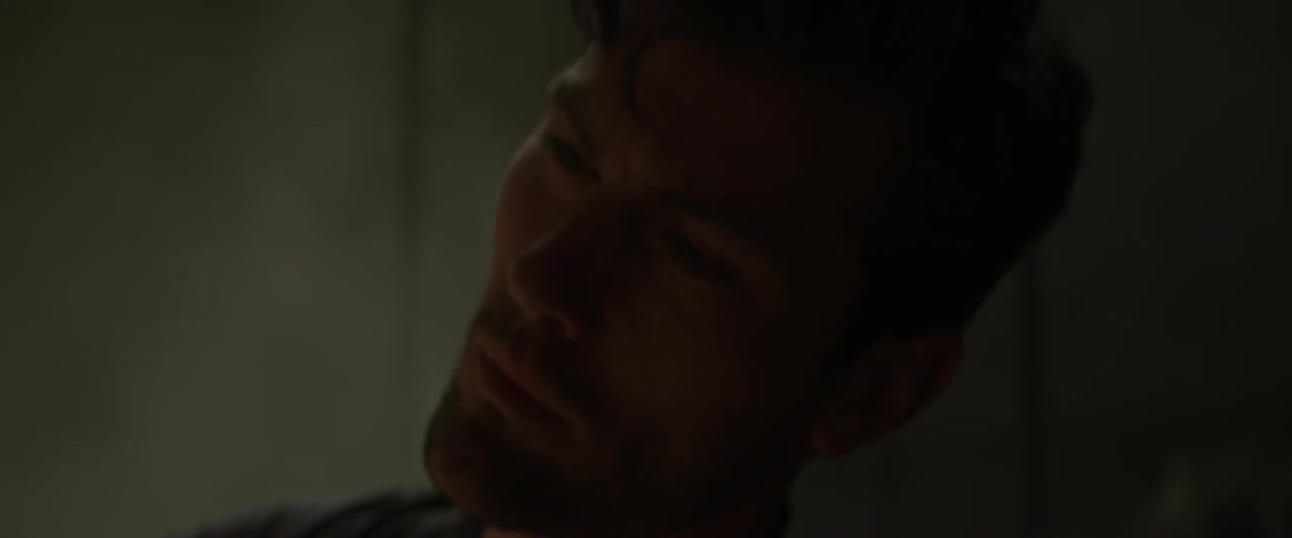 A man squints his eyes and tilts his head to the side