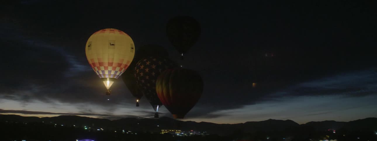 Hot air balloons lighting up at night