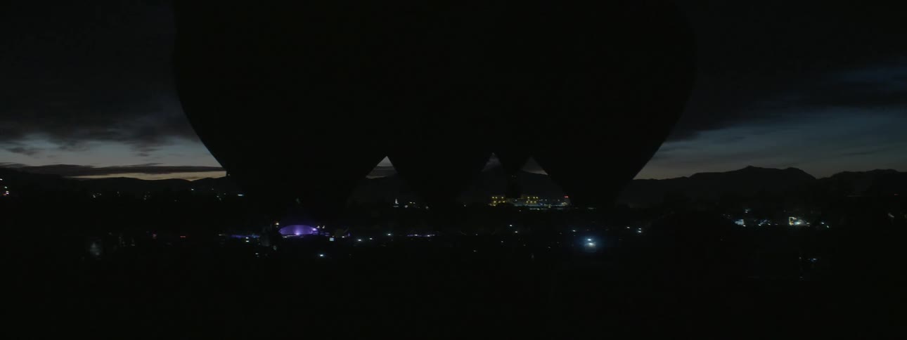 Hot air balloons flicker in the night sky