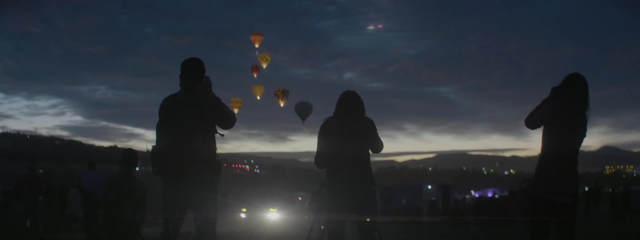 People watch as the hot air balloons sail into the sky