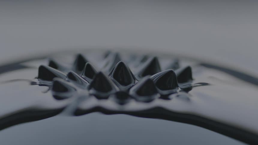 Black liquid ripples up into a spiked pattern
