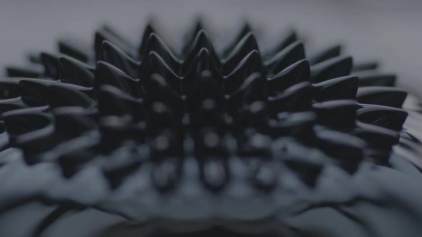 A black liquified substance moves and shifts in abstract