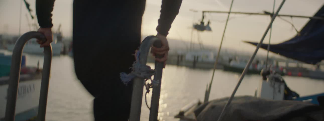 A man is running along a dock and onto a boat