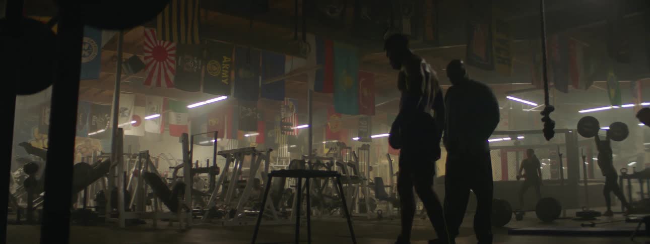 A man exercises in a gym by hopping on a platform