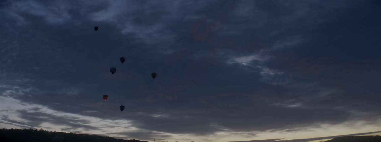 Hot air balloons flicker in the night sky