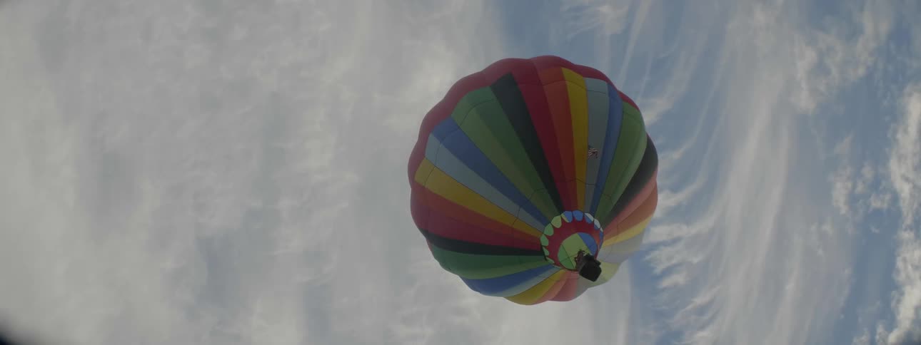A hot air balloon floats in a cloudy sky