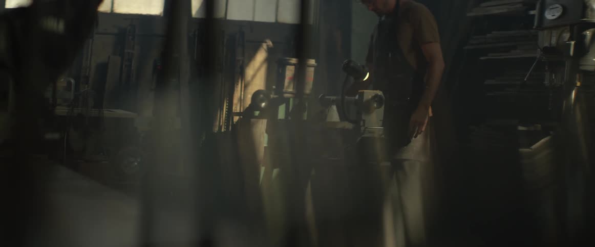 A man works with a lathe in a workshop