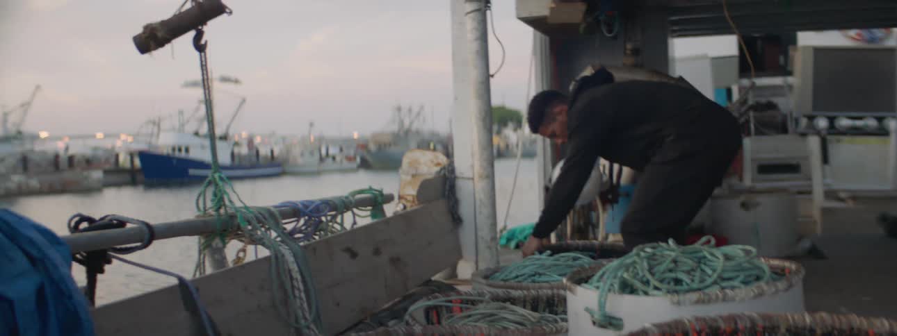 A man carries a basket on a fishing boat