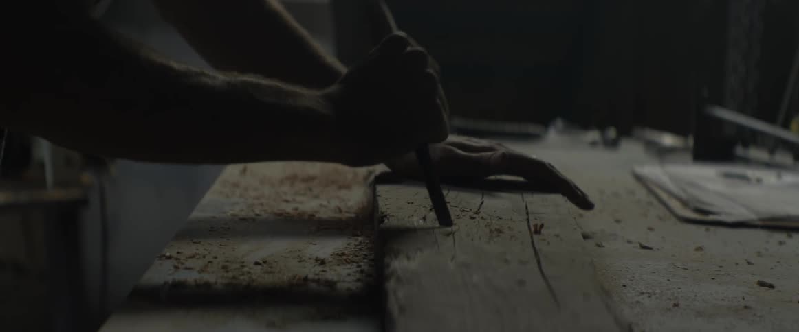 A man chisels a piece of wood
